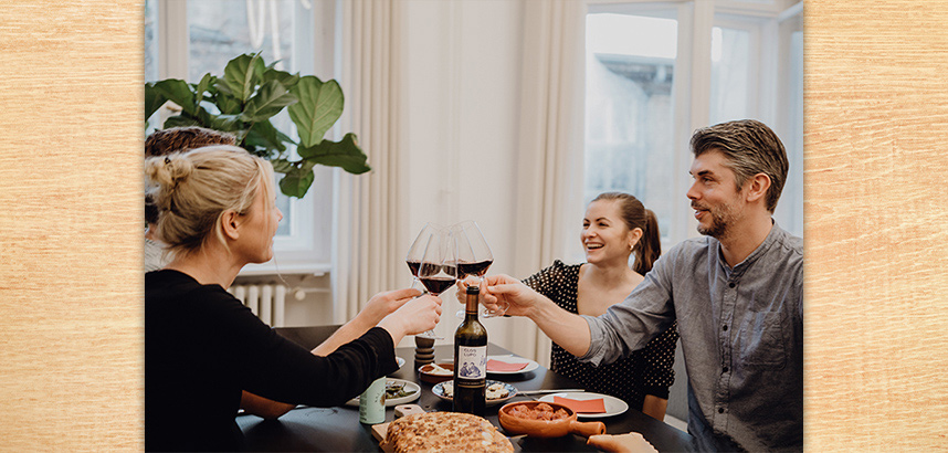 VINOS-Weinentdecker stoßen beim Abendessen mit Weingläsern an.